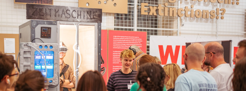 Banner Regelmäßge Veranstaltungen; Menschenmenge vor Ausstellung zu Zukunfsvisionen
